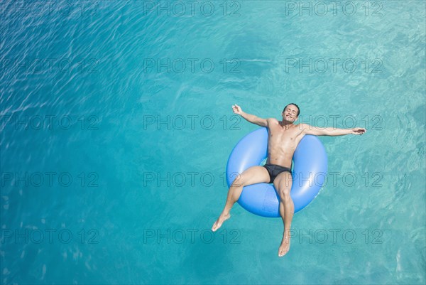 Hispanic man on float in water
