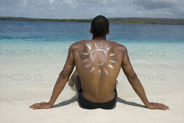 Hispanic man sitting on beach