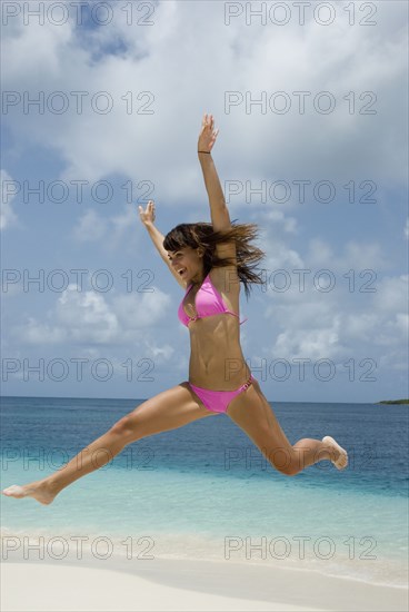 Young woman jumping at beach