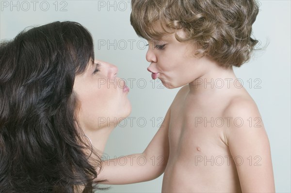 Hispanic mother and son blowing kisses