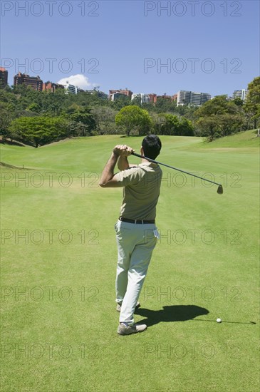 Hispanic man playing golf