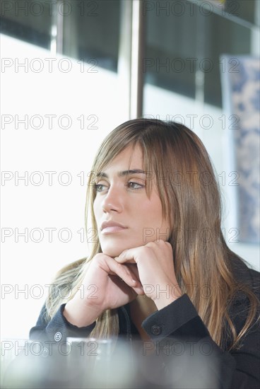 Hispanic woman looking out window