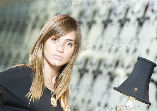 Portrait of Hispanic woman next to lamp