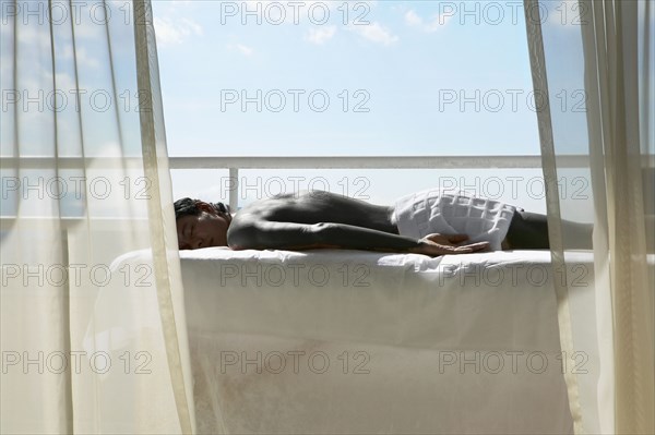 Man laying on massage table on balcony