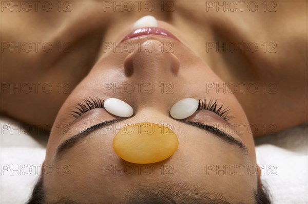 Close up of Hispanic woman receiving stone spa treatment