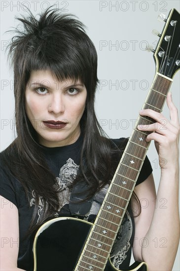 Hispanic woman holding guitar