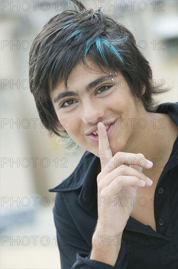 Hispanic teenager making silence motion