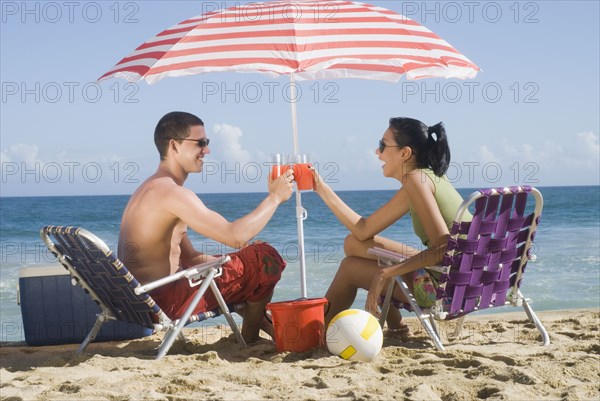 Hispanic couple relaxing at beach