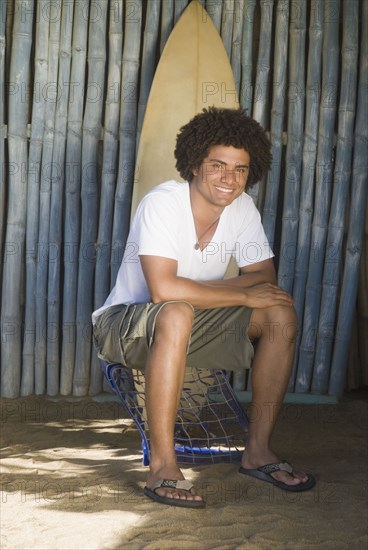 African man outdoors with surfboard