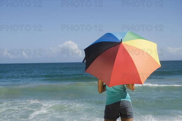 African woman at beach with umbrella