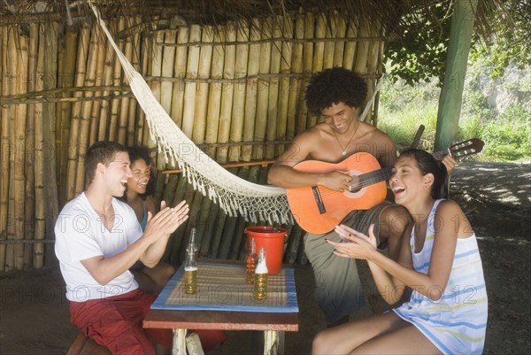 Friends listening to man play guitar