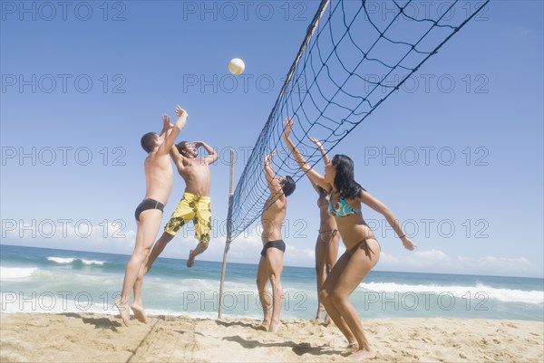 Multi-ethnic friends playing volleyball at beach