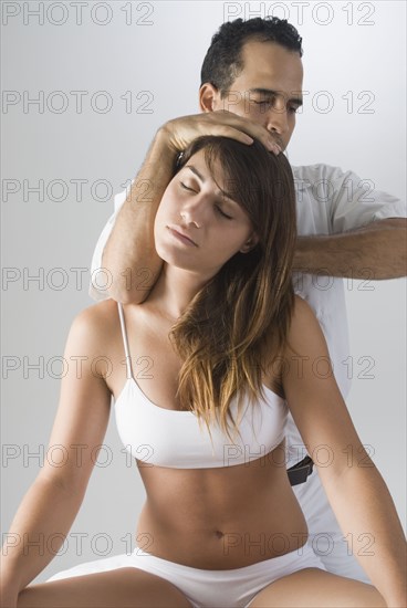 Chiropractor adjusting woman's neck