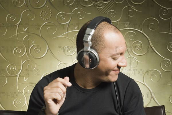 Hispanic man listening to headphones