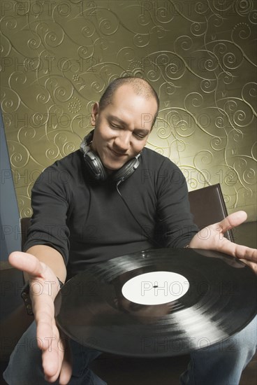 Hispanic man holding vinyl record