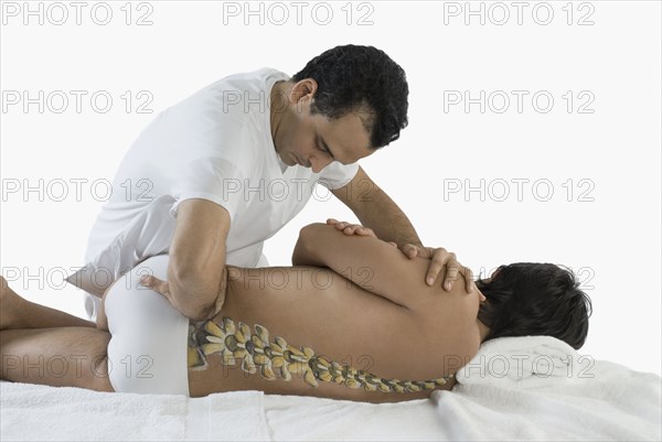 Chiropractor adjusting man's back