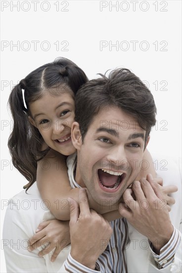 Hispanic father giving daughter piggyback ride