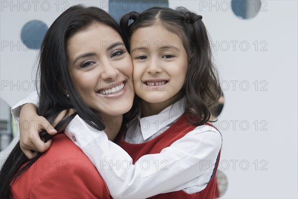 Hispanic mother hugging daughter