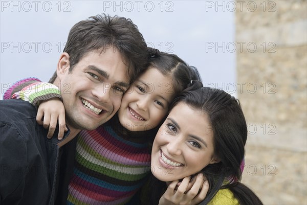 Happy Hispanic family hugging