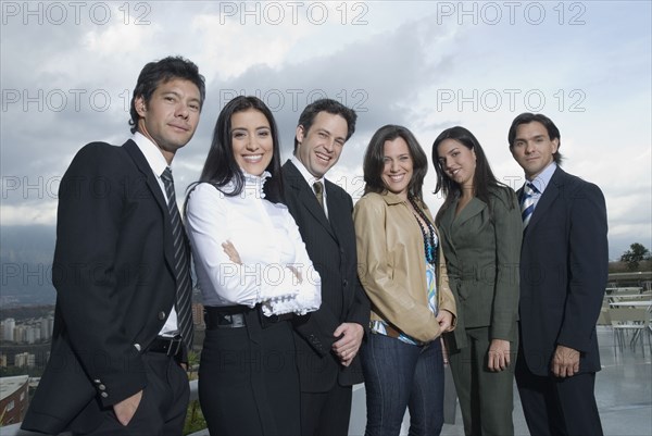 Hispanic co-workers standing in row