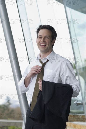 Hispanic businessman loosening necktie