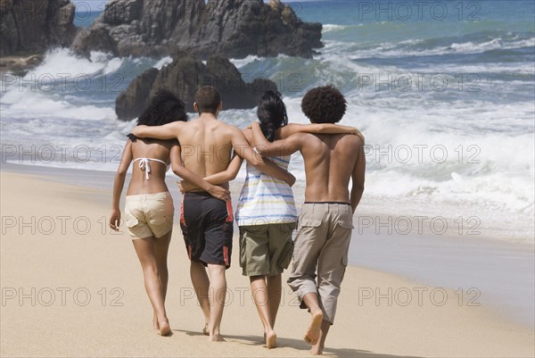 Multi-ethnic friends walking on beach