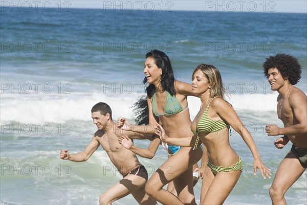 Multi-ethnic friends running on beach