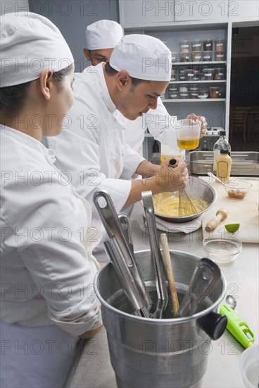 Baker stirring batter in bakery kitchen