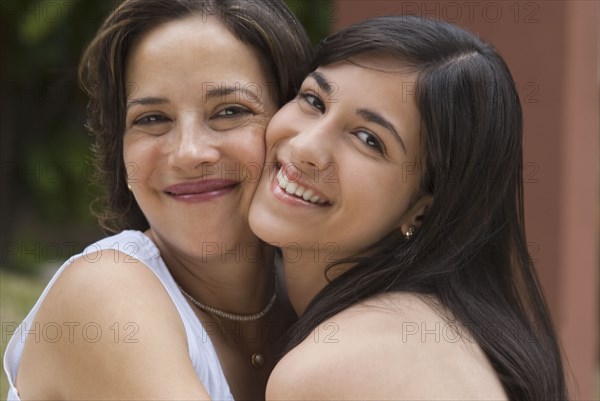 Hispanic mother and daughter hugging