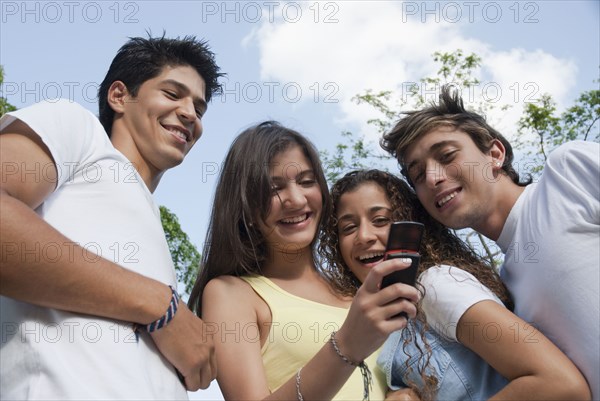Hispanic friends looking at cell phone together