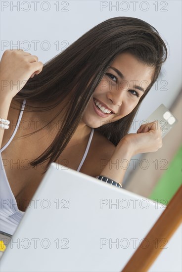 Hispanic woman shopping online with credit card