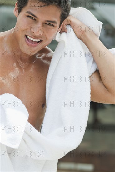 Wet Hispanic man drying off