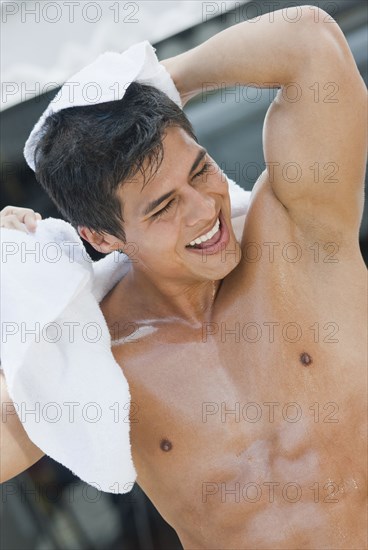 Wet Hispanic man drying off