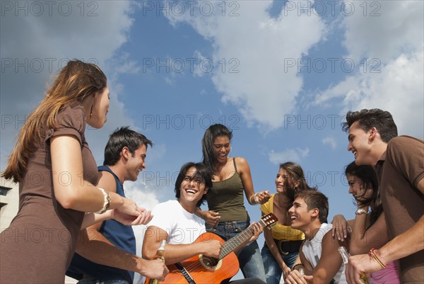 Friends listening to man playing guitar