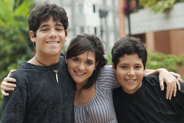 Hispanic mother and sons hugging