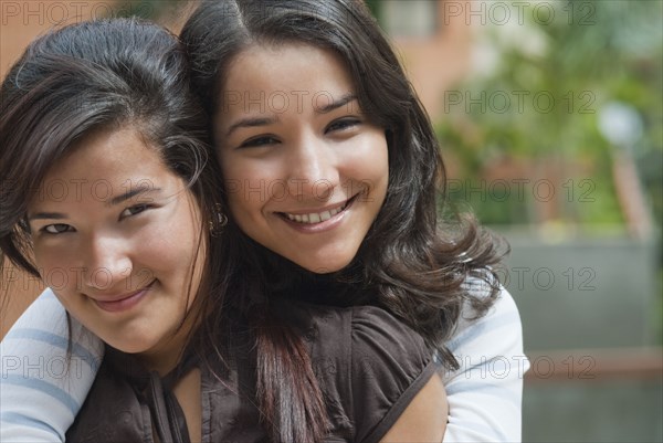 Hispanic sisters hugging