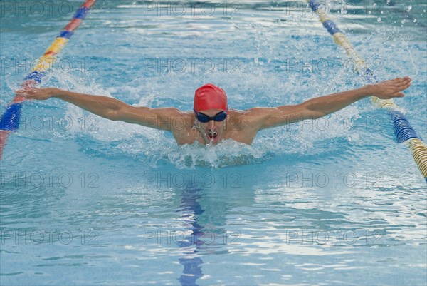 Hispanic man swimming in swimming pool