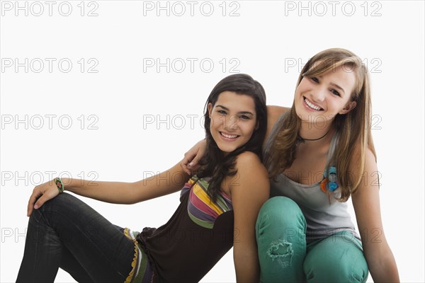 Smiling Hispanic sisters hugging