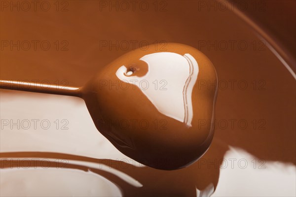 Heart-shaped candy being dipped in chocolate