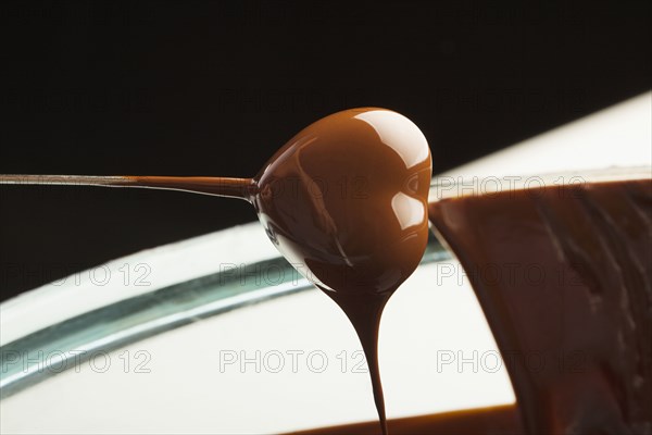 Heart-shaped candy being dipped in chocolate