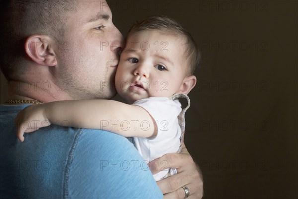 Caucasian father kissing son