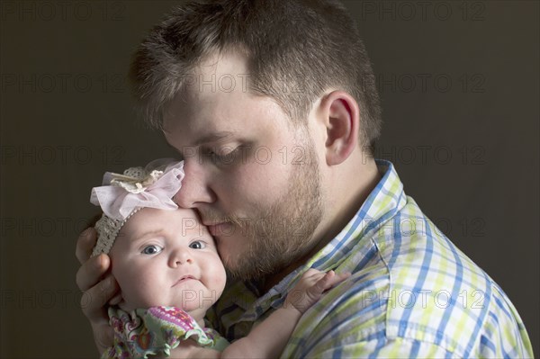 Caucasian father holding daughter