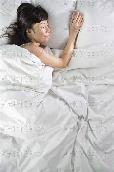 Mixed race woman sleeping in bed