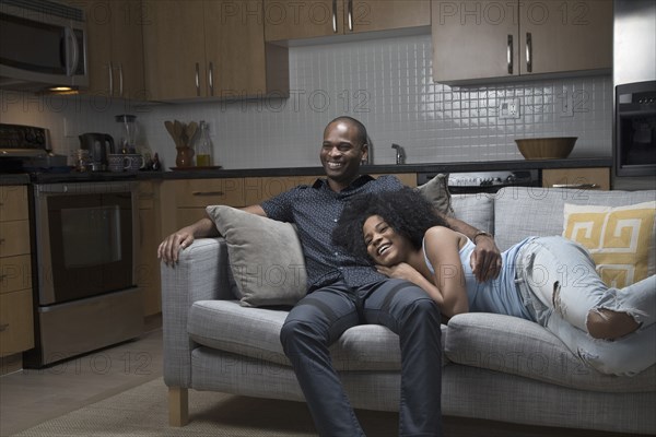 African American couple relaxing on sofa