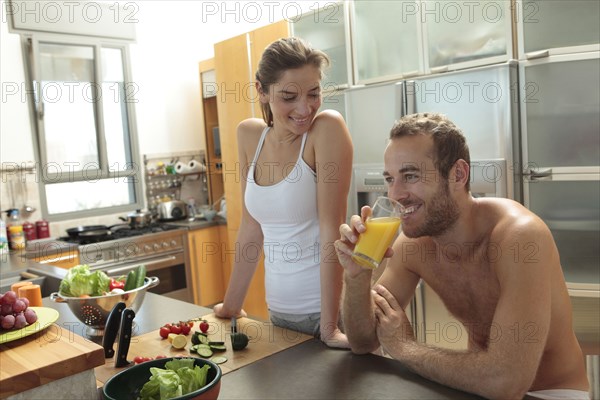 Caucasian couple preparing food in kitchen