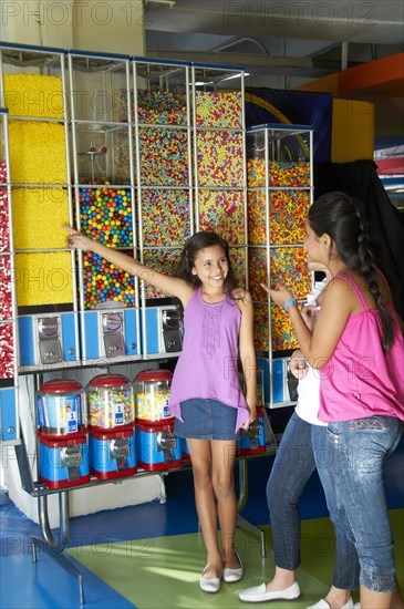 Hispanic girls looking at candy dispensers