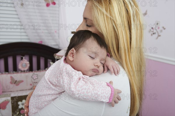 Hispanic mother holding baby daughter