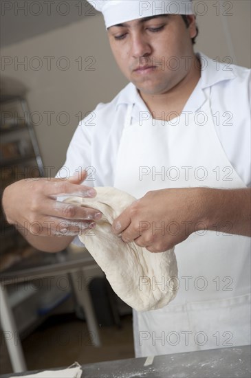 Hispanic baker working in commercial kitchen