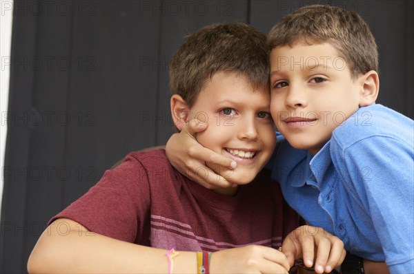 Smiling Hispanic boys hugging