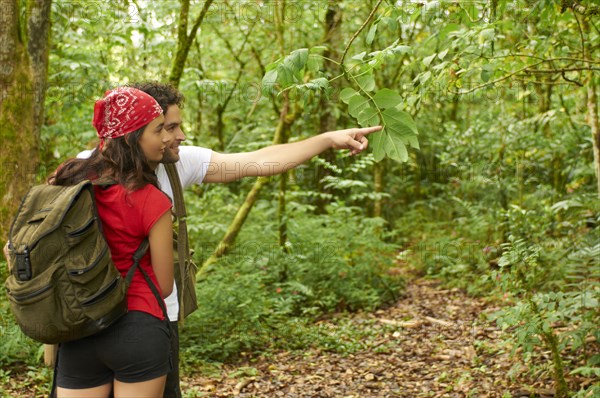 Hispanic couple hiking together in forest